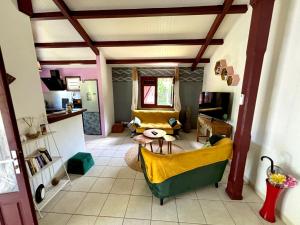 ein Wohnzimmer mit einer Couch und einem Tisch in der Unterkunft La Maison Créole du Flamboyant - Proche des Plages in Anse-Bertrand