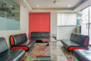 a waiting room with leather couches and a red wall at Super OYO Flagship Hotel Mv Galaxy in Dāpuri