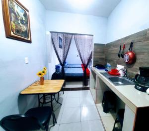 una pequeña cocina con mesa y fregadero en Departamento Pacífico en Mazatlán