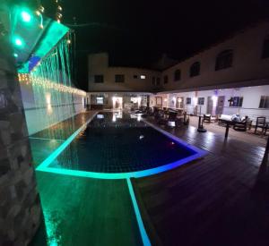 una piscina por la noche con luces encendidas en Tacuru Hotel Boutique, en Salto del Guairá