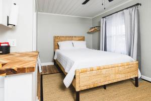 a bedroom with a wooden bed and a window at Seabirds Motel At Kure Beach in Kure Beach