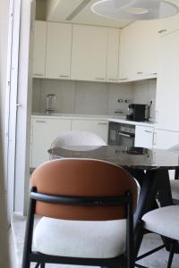a kitchen with a table and a chair in a room at Island, Pool & Sea Apartment in Chicala