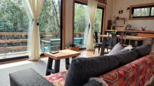 uma sala de estar com um sofá e uma mesa em Tres Bosques em Pucón