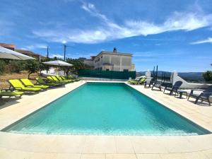 - une piscine avec des chaises et une maison dans l'établissement Casa de Cardigos, à Cardigos