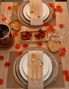 a table with plates and forks and napkins on it at Flat B306 Village Aldeia das Águas in Barra do Piraí