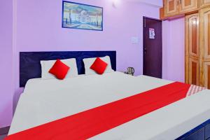 a bedroom with a large bed with red pillows at Super Hotel O New View in Bankipur +21 photos