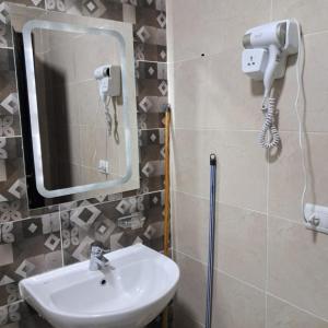a bathroom with a sink and a mirror at استديو فندقى مكيف بتراس اكوا فيو Aquaview in El Alamein