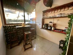 a kitchen with a counter and stools in a room at Beautiful View House in Tortuguero