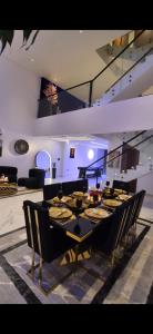 Un comedor con una mesa larga y sillas. en Al MULHIM VILLA إستراحة الملهم, en Rumays 27 fotos más