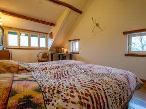 een slaapkamer met een bed in een kamer met ramen bij Atelier Roza in Lottum