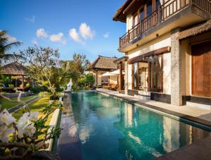 una piscina frente a una casa en Balangan Beach Villa, en Jimbaran