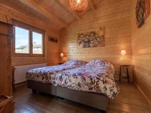 ein Schlafzimmer mit einem Bett in einer Holzhütte in der Unterkunft Onder de oude Eik in Lottum