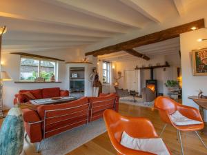 een woonkamer met oranje stoelen en een bank bij Atelier Roza in Lottum