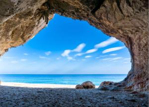 a view of the ocean from a cave on a beach at La Grotta Sardegna 5 Bedrooms each with a Private Ensuite Bathroom featuring a Hydromassage Shower Air Conditioning in Urzulei +18 photos