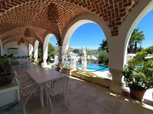 a patio with a table and chairs and a swimming pool at DAR BELDI in Hammamet
