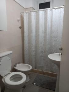Un baño con inodoro, lavabo y ducha. en Dpto 1 dormitorio a 2 cuadras de Parque de Mayo, en San Juan