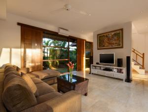 a living room with a couch and a television at Balangan Beach Villa in Jimbaran