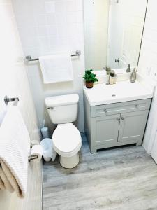 a white bathroom with a toilet and a sink at Cozy Getaway in Orlando