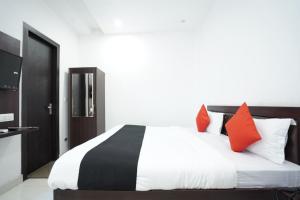 Karnal的住宿－Hotel Star Inn，一间卧室配有一张带红色枕头的大床