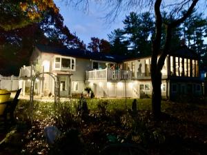a large white house with people on the balcony at Clear Pond Suite in Plymouth