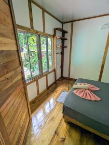 Arboura Eco Cabins في أوفيتا: غرفة بسرير وأرضيات خشبية ونوافذ