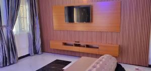 ein Wohnzimmer mit einem TV an der Wand in der Unterkunft SHORT Rental in Ilorin