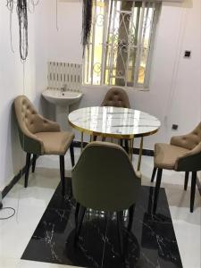 een eetkamer met een glazen tafel en stoelen bij SHORT Rental in Ilorin
