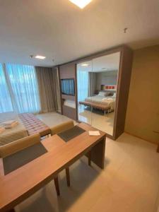 a bedroom with two beds and a table and a mirror at Flat Particular no Jade Brasília - Arejado e Rigorosa Limpeza! in Brasilia