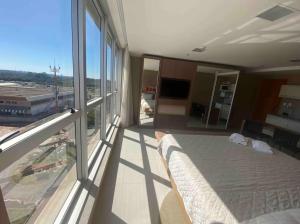 a bedroom with a bed and a large window at Flat Particular no Jade Brasília - Arejado e Rigorosa Limpeza! in Brasilia