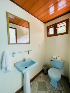a bathroom with a blue toilet and a sink at Cabinas Nuestra Kasa in Monteverde Costa Rica