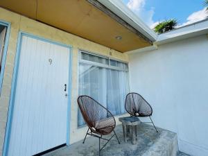 dos sillas y una mesa frente a un edificio en Cabinas Nuestra Kasa, en Monteverde