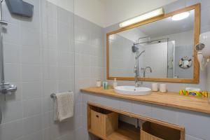 un bagno con lavandino e specchio di Appartement Macaron Clair a Le Diamant
