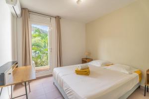 una camera da letto con un grande letto bianco e una finestra di Appartement Macaron Clair a Le Diamant