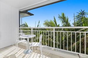 a patio with two chairs and a table on a balcony at Resort Rooms at Gunnamatta Ave in Kingscliff