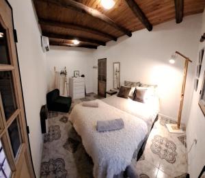 a bedroom with a bed and a chair in a room at CASA ADAGIO in Ciudad Lujan de Cuyo