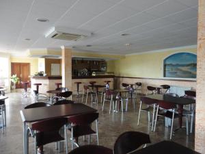 un restaurante con mesas y sillas en una habitación en Hotel Brisa, en A Lanzada