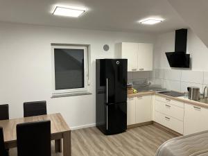 a kitchen with a black refrigerator and a table at Apartment house Petra in Cerklje na Gorenjskem +7 photos