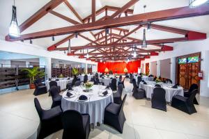 un salón de banquetes con mesas blancas y sillas negras en Tanoa Tusitala Hotel en Apia
