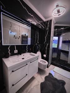 a bathroom with a white sink and a toilet at Cozy Apartament in Center of Bucharest in Bucharest
