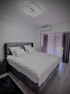 sypialnia z dużym łóżkiem z białą pościelą w obiekcie Cozy Apartament in Center of Bucharest w Bukareszcie