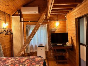 a bedroom with a computer and a desk with a monitor at kinkonkan in Oguni