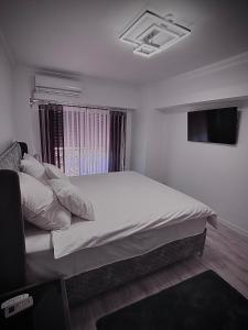 a bedroom with a large bed with a tv on the wall at Cozy Apartament in Center of Bucharest in Bucharest