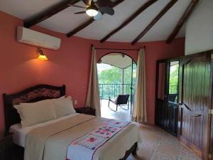 ヒリトゥラにあるHotel Paraíso Encantadoのベッドルーム1室(ベッド1台付)、バルコニーへのドアが備わります。