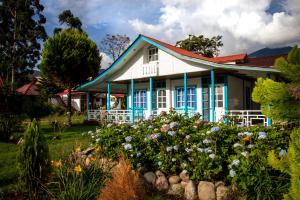 奧克薩潘帕的住宿－Cemayu Lodge，院子里白色和蓝色的房子,花朵花