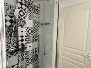 y baño con ducha y azulejos blancos y negros. en Appartement Arcachon, 3 pièces, 4 personnes - FR-1-374-161, en Arcachon