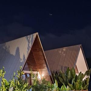 a house with a metal roof at night at Volcano White Glamping in Kubupenlokan