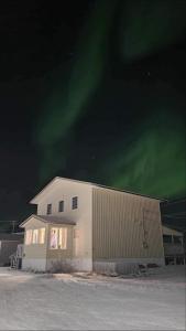 a building with the aurora in the sky at Inukshuk Rooms in Churchill