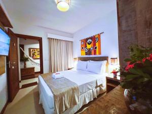 a hotel room with a bed and a television at Pousada João Sol in Praia do Forte
