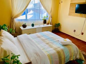 sypialnia z łóżkiem z dwoma ręcznikami w obiekcie Casa Bonita w mieście Guadalajara