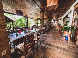 a restaurant with wooden floors and tables and chairs at Pousada João Sol in Praia do Forte